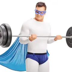 Superbohater w masce i pelerynie wykonuje trening HST z ciężarem.
