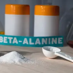Biały proszek beta alaniny na blacie, gotowy do suplementacji. Może wywołać charakterystyczne mrowienie.