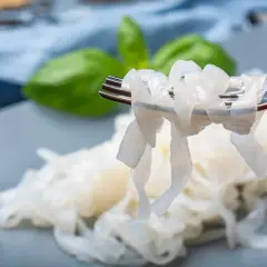 Nici z konjac na widelcu, obok liści bazylii. To zdrowa alternatywa dla tradycyjnego makaronu.