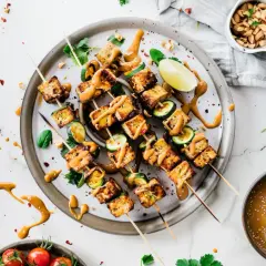 Szaszłyki z tofu, grillowane z cukinią, polane sosem orzechowym i posypane sezamem. Idealne na letnie przyjęcie.