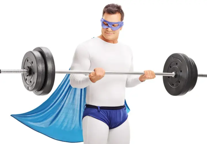 Superbohater w masce i pelerynie wykonuje trening HST z ciężarem.