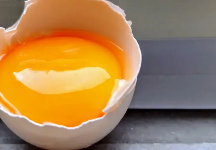 Rozbite jajko z płynnym żółtkiem i białkiem, gotowe do przygotowania posiłku bogatego w **egg protein**.