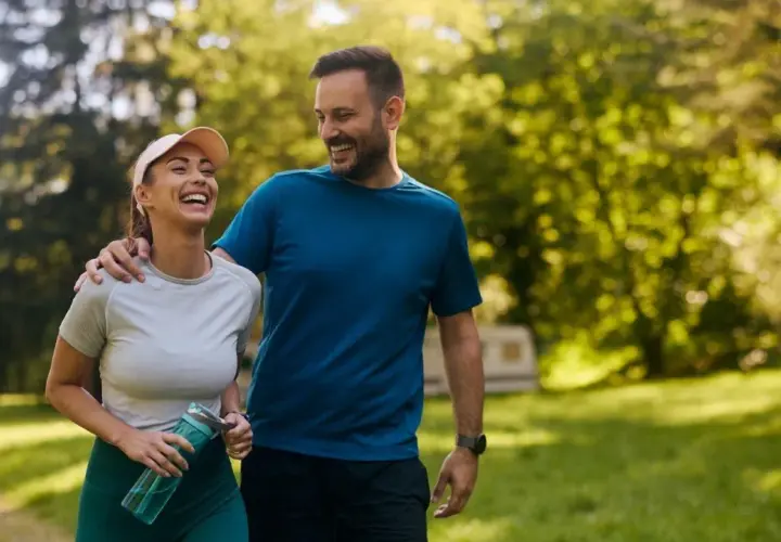 Szczęśliwa para spaceruje po parku. Czy koenzym q10 rano czy wieczorem? Zależy od Twojego stylu życia!