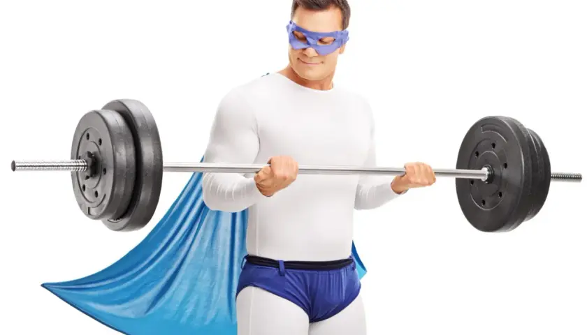 Superbohater w masce i pelerynie wykonuje trening HST z ciężarem.
