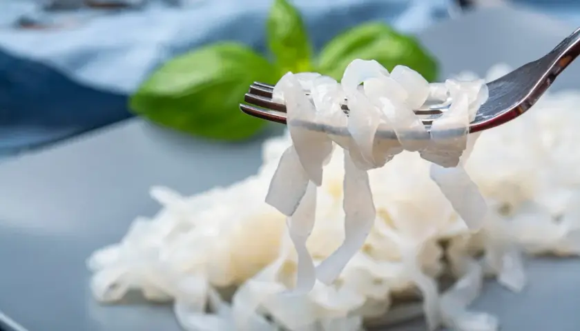 Nici z konjac na widelcu, obok liści bazylii. To zdrowa alternatywa dla tradycyjnego makaronu.