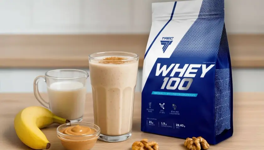 Bananowy koktajl z białkiem z wodą czy mlekiem? Obok opakowanie WHEY 100, masło orzechowe i orzechy.
