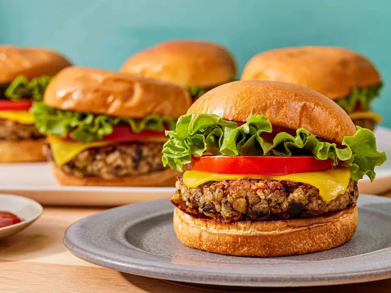 Pyszny vege burger z soczystą kotletką, serem, pomidorem i sałatą na miękkiej bułce.